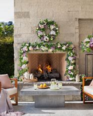 Outdoor patio with fireplace decorated with artificial floral wreath and garland
