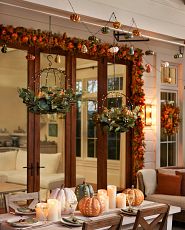 Fall tablescape with candles, lighted pumpkins, and autumn foliage