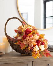 Cornucopia with artificial apples, flowers, and leaves