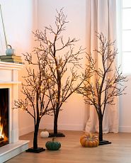 Lit twig tree and pumpkin décor accents