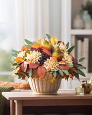 Artificial flower arrangement with pears, dahlias, and pinecones